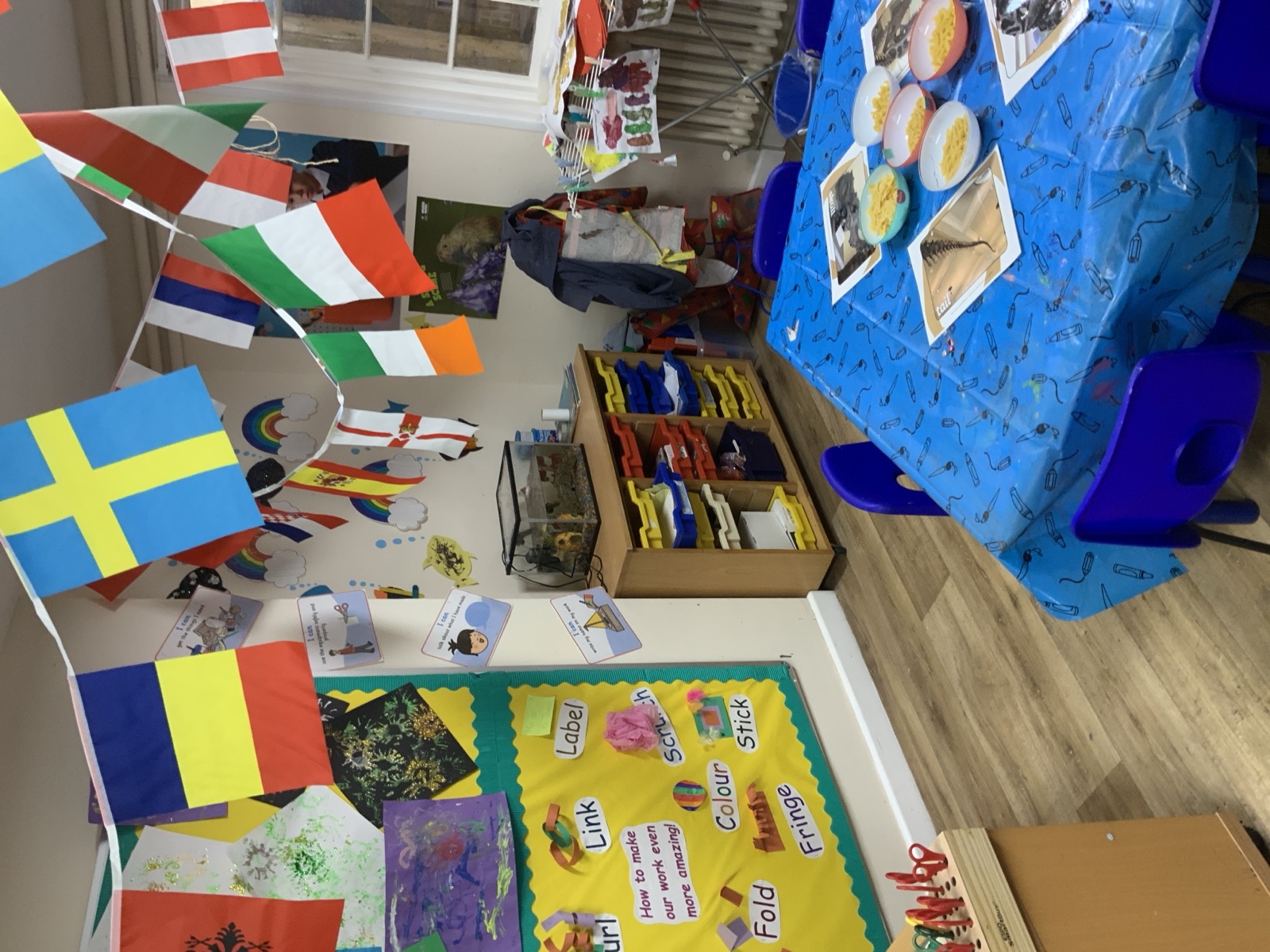 A bright classroom with children's work and international flags
